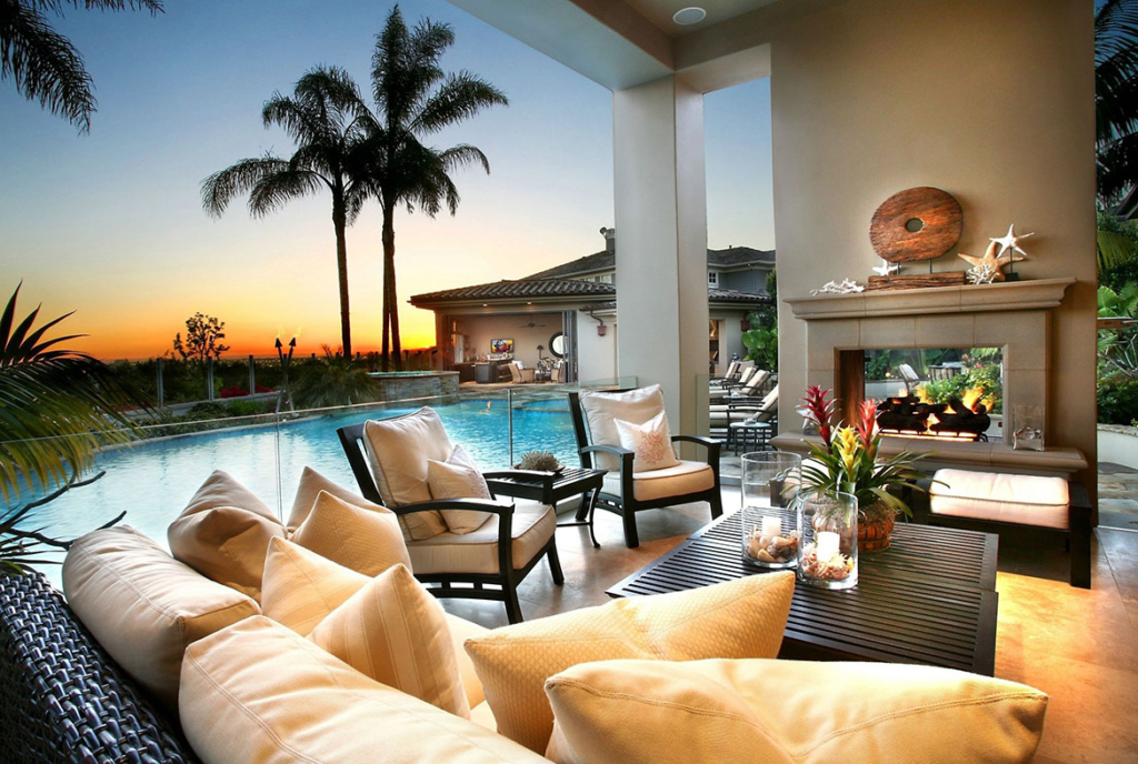 A living room with couches and chairs next to the pool.
