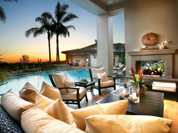 A living room with couches and chairs next to the pool.