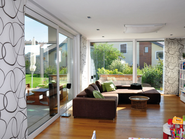 A living room with large windows and wooden floors.