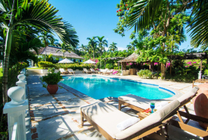 A pool with a sun lounger and umbrella