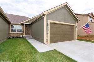 A house with a garage and driveway in front of it.